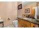 Powder room features granite counters, wood cabinet, framed art and clean white toilet at 11730 Pointe View Dr, Longmont, CO 80503