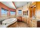 Bright bathroom featuring a soaking tub, dual sinks, and large windows with scenic views at 11730 Pointe View Dr, Longmont, CO 80503
