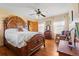 A primary bedroom with a hardwood floor, ceiling fan, and a large wooden bed frame and dresser at 11730 Pointe View Dr, Longmont, CO 80503