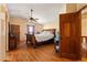 Primary bedroom with hardwood floors, ceiling fan, arched doorways, and wood furniture at 11730 Pointe View Dr, Longmont, CO 80503