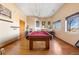 Spacious game room with hardwood floors, a pool table, and natural light from a large window at 11730 Pointe View Dr, Longmont, CO 80503