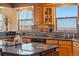 Close up of eat-in kitchen with granite countertops, wood cabinets, and views of distant hills at 11730 Pointe View Dr, Longmont, CO 80503