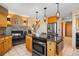 Open kitchen with island cooktop, granite countertops, and fireplace in connected living space at 11730 Pointe View Dr, Longmont, CO 80503