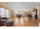 Spacious living room with bright hardwood floors, multiple guitars, a piano, and comfortable seating at 11730 Pointe View Dr, Longmont, CO 80503