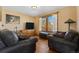 Cozy living room with hardwood floors, leather sofas, lamps, and view of outside at 11730 Pointe View Dr, Longmont, CO 80503