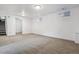 Finished basement with neutral carpet, white walls, and an open door with stairs at 7724 S Lafayette Ct, Centennial, CO 80122
