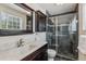 Modern bathroom with dark wood vanity, marble countertop, and glass shower with tile surround at 7724 S Lafayette Ct, Centennial, CO 80122