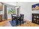 Bright dining room features wood floors and a modern light fixture above a round, dark wood table at 7724 S Lafayette Ct, Centennial, CO 80122