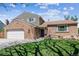 Charming brick home featuring an attached garage, landscaped front yard, and inviting entrance at 7724 S Lafayette Ct, Centennial, CO 80122
