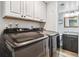 Well-equipped laundry room with modern washer and dryer, storage cabinets, and access to half bathroom at 7724 S Lafayette Ct, Centennial, CO 80122