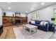Cozy living room featuring a brick fireplace with built-in shelves and a comfortable blue sofa at 7724 S Lafayette Ct, Centennial, CO 80122