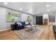 Inviting living room with hardwood floors, blue sofa, and a sliding door leading to the outdoors at 7724 S Lafayette Ct, Centennial, CO 80122
