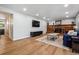 Open-concept living room with a fireplace, mounted TV, hardwood floors, and plenty of natural light at 7724 S Lafayette Ct, Centennial, CO 80122