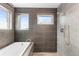 Bathroom featuring a soaking tub, modern tile, and dual windows for natural light at 5 Harrison St, Denver, CO 80206