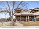 Charming two-story home featuring a covered porch with stone columns and a manicured front yard at 5 Harrison St, Denver, CO 80206