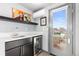 Home wet bar area featuring a sink, beverage fridge, and access to an outdoor patio at 5 Harrison St, Denver, CO 80206