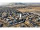 An aerial view of a residential neighborhood near open fields and mountains shows the home's ideal location at 6290 Virgil St, Arvada, CO 80403