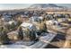 Picturesque winter aerial view of homes in a neighborhood, showcasing landscaping and mountain backdrop at 6290 Virgil St, Arvada, CO 80403