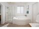 Elegant bathroom showcasing a separate glass-enclosed shower and a luxurious corner tub for relaxation at 6290 Virgil St, Arvada, CO 80403