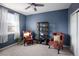 Serene bedroom with blue accent wall, comfortable seating, and ample natural light creates a relaxing retreat at 6290 Virgil St, Arvada, CO 80403