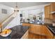 Open kitchen featuring granite countertops, wood cabinets, and a view into the living room and stairway at 6290 Virgil St, Arvada, CO 80403