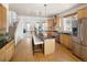 Spacious kitchen featuring a large island with seating, stainless steel appliances, and wood flooring at 6290 Virgil St, Arvada, CO 80403