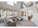 Open-concept living room featuring high ceilings, large windows, and a view of the kitchen area at 6290 Virgil St, Arvada, CO 80403