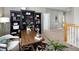 Home office with dark bookshelves, a cowhide rug and a large wooden desk at 6290 Virgil St, Arvada, CO 80403