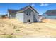 New construction home featuring gray siding, white trim, basement access, and a wooden back deck with stairs at 39628 Yorktown Ter, Elizabeth, CO 80107
