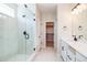 Bright bathroom with a glass shower, double sinks, and a walk-in closet for maximum convenience at 39628 Yorktown Ter, Elizabeth, CO 80107