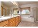 Bathroom with double sink vanity, bathtub, and glass door shower, all in a neutral color palette at 698 Larimer Creek Dr, Monument, CO 80132