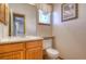 Half bathroom featuring a wood vanity with sink and a window above the toilet at 698 Larimer Creek Dr, Monument, CO 80132