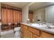 Well-lit bathroom featuring a wood vanity with sink, and a shower with a decorative curtain at 698 Larimer Creek Dr, Monument, CO 80132