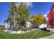Charming home featuring a landscaped front yard with rock details and mature trees at 698 Larimer Creek Dr, Monument, CO 80132