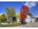 Charming home with landscaped front yard and mature trees in vibrant autumn colors at 698 Larimer Creek Dr, Monument, CO 80132