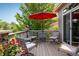 A stunning outdoor deck with wood floors, outdoor furniture, and an umbrella at 13943 W 87Th Ln, Arvada, CO 80005