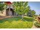 Beautiful backyard showcasing the outdoor deck, large lawn and stonework at 13943 W 87Th Ln, Arvada, CO 80005