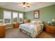Tranquil bedroom with natural light from the shuttered windows, carpeted floor, ceiling fan, and matching wooden furniture at 13943 W 87Th Ln, Arvada, CO 80005