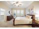 A bright bedroom with a walk-in closet, neutral walls, and light carpeting, with dresser, tables, and queen bed at 13943 W 87Th Ln, Arvada, CO 80005