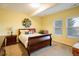 Bright bedroom with yellow walls, large bed, and two windows at 13943 W 87Th Ln, Arvada, CO 80005