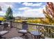 A spacious outdoor deck featuring comfortable seating with a scenic view of a peaceful lake and distant mountains at 13943 W 87Th Ln, Arvada, CO 80005