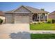 Charming single-story home with a three-car garage, stone accents, and well-manicured lawn and landscaping at 13943 W 87Th Ln, Arvada, CO 80005