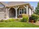 Inviting front porch, beautiful landscaping, and stacked stone accents at 13943 W 87Th Ln, Arvada, CO 80005