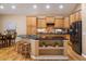 Open kitchen features wood cabinets, an island, and stainless steel appliances at 13943 W 87Th Ln, Arvada, CO 80005