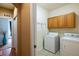 Bright laundry room with upper cabinets, washer, and dryer at 13943 W 87Th Ln, Arvada, CO 80005