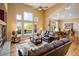 Open-concept living room with a vaulted ceiling, hardwood floors, and large windows at 13943 W 87Th Ln, Arvada, CO 80005