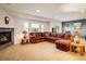Cozy living room with a fireplace, comfortable seating, and plenty of natural light at 13943 W 87Th Ln, Arvada, CO 80005