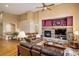 Cozy living room with a stone fireplace, hardwood floors, and a comfortable leather sofa at 13943 W 87Th Ln, Arvada, CO 80005