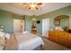 Spacious main bedroom showing private bath access, tub, carpeted floor, ceiling fan, and a dresser with a large mirror at 13943 W 87Th Ln, Arvada, CO 80005