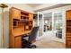 A well-lit office space with custom wood built-ins, open to the living room through glass pane french doors at 13943 W 87Th Ln, Arvada, CO 80005